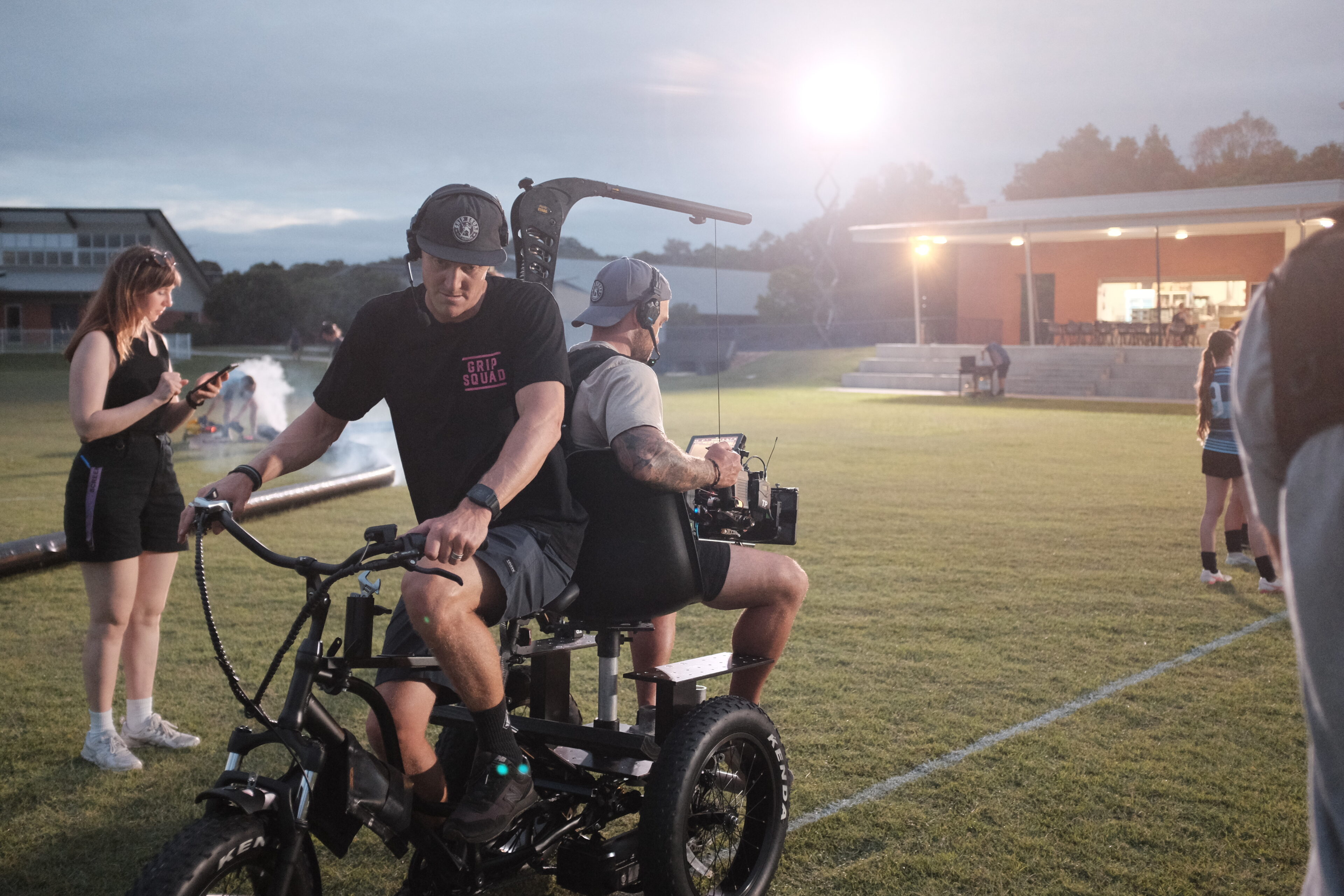 Cinematographer on commercial video rides on trike with grip